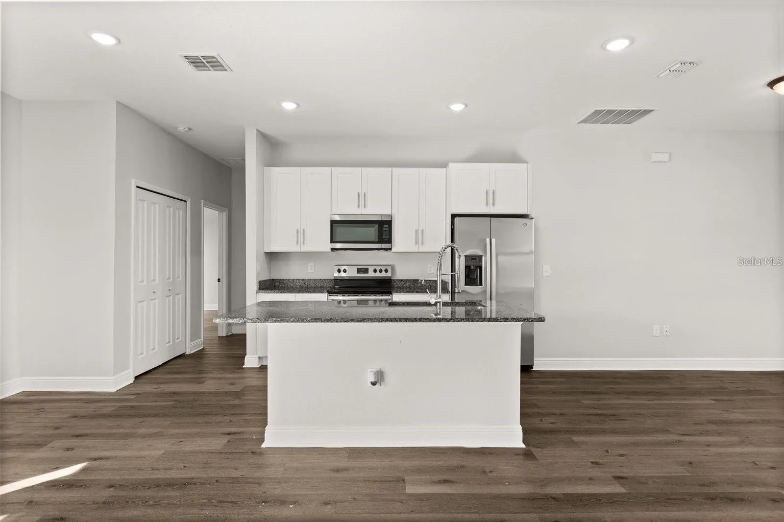 Kitchen comes with stainless steel appliances and an island