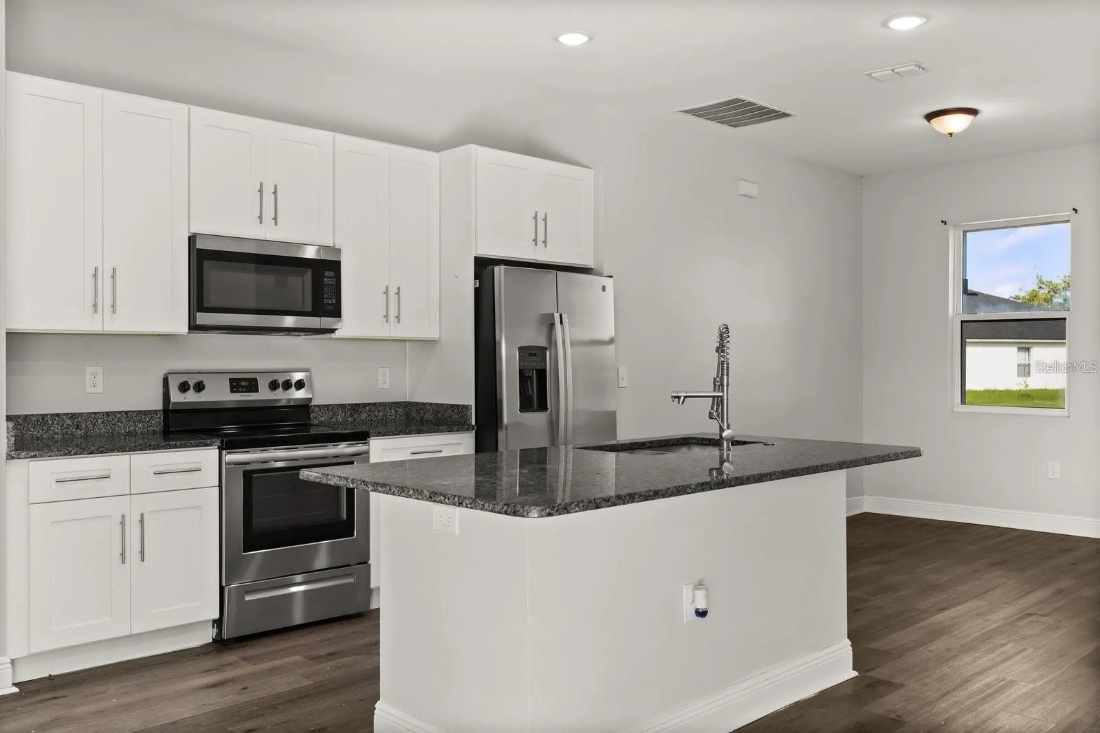 Kitchen comes with stainless steel appliances and an island