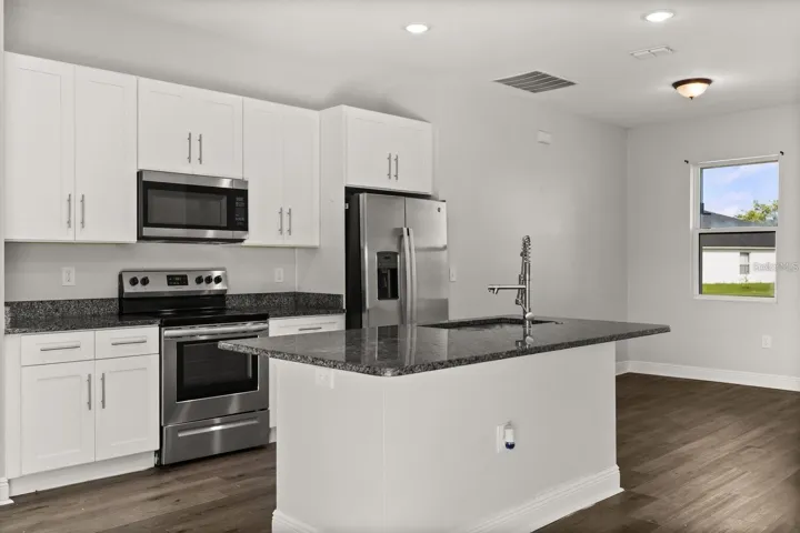 Kitchen comes with stainless steel appliances and an island