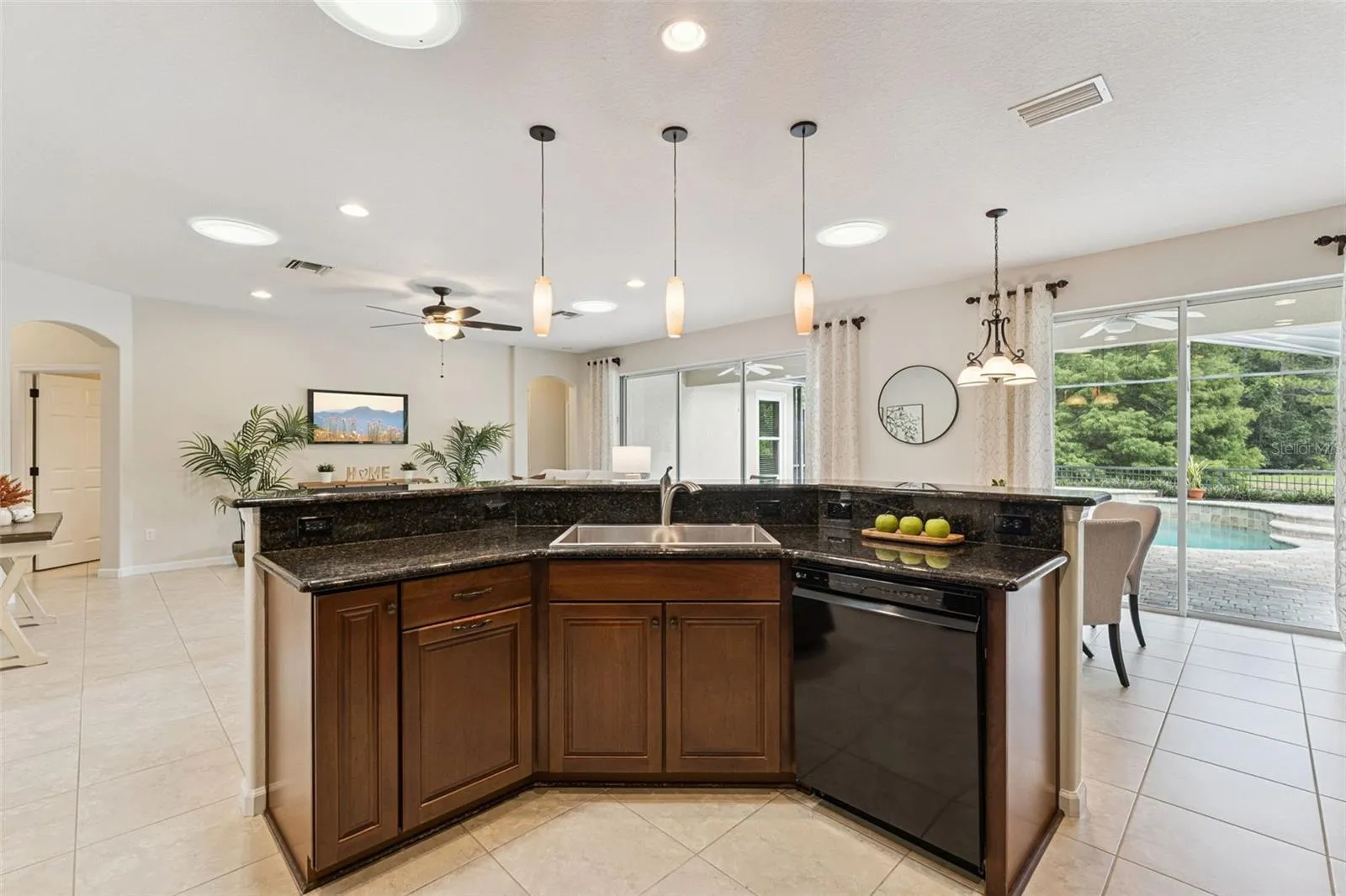 View of the Great Room & screen enclosed heated pool from the Kitchen area