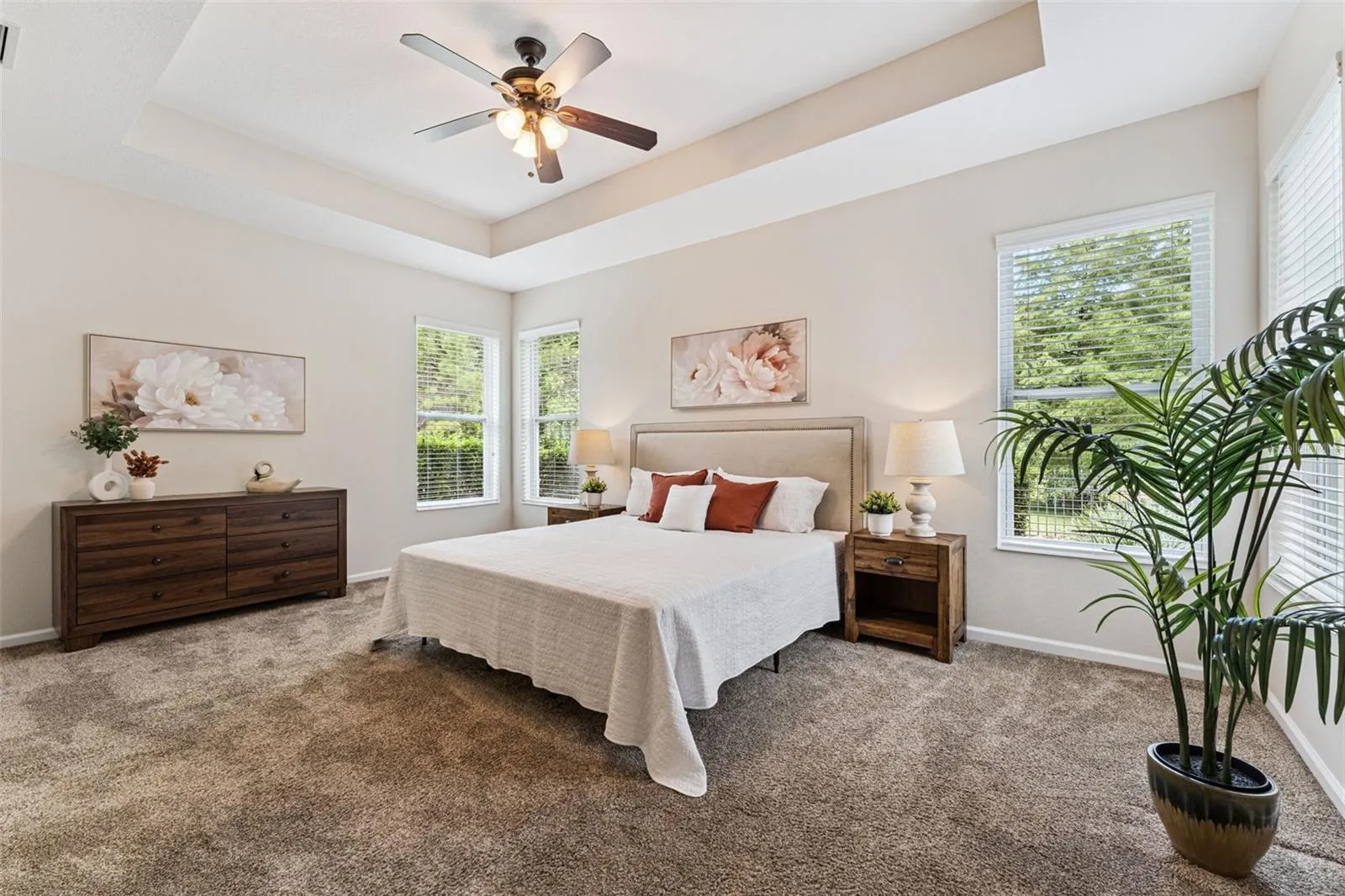 18'6" x 13' Primary Bedroom w/ a tray ceiling & ceiling fan