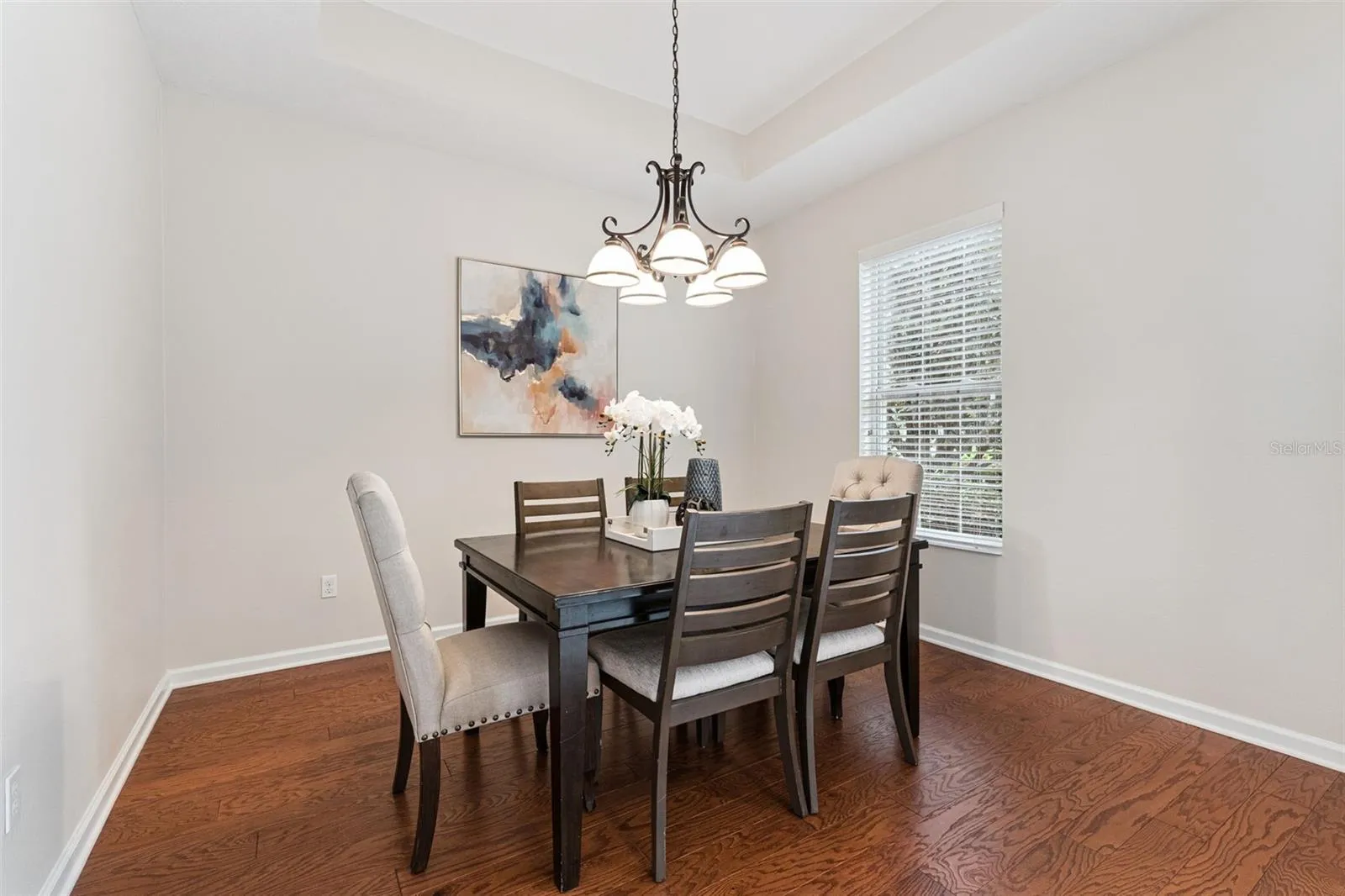 11'6" x 11'9" Dining Room w/ a tray ceiling & engineered wood flooring
