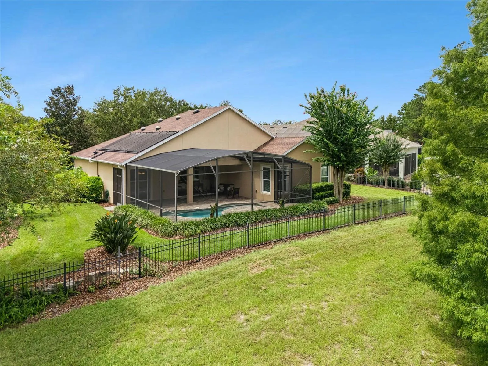 Aerial view of the aluminum rail fenced backyard & rear of the home