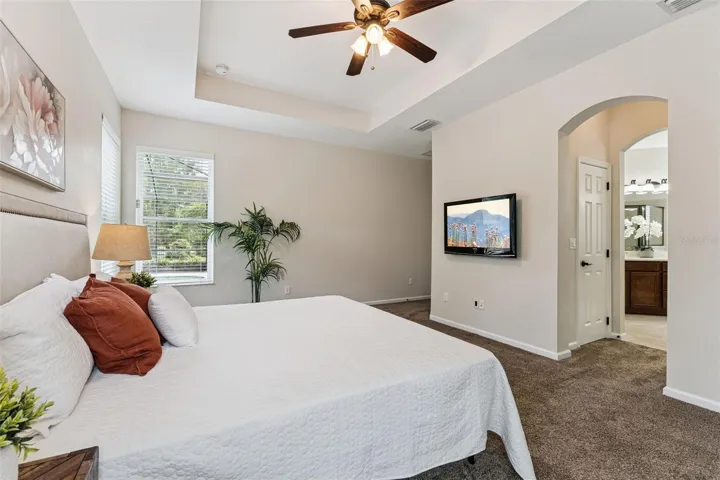 Primary Bedroom w/ a wall-mounted TV