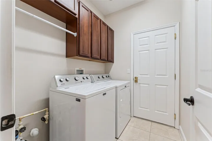 5'6" x 7' Utility Room w/ washer, natural gas dryer, storage cabinets & pre-plumbing for a future laundry tub