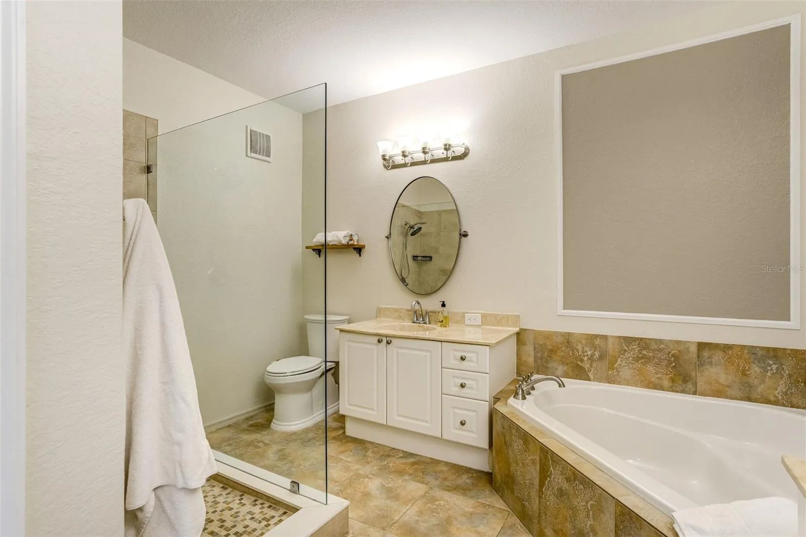 Bathroom with garden tub, dual vanities and walk in shower
