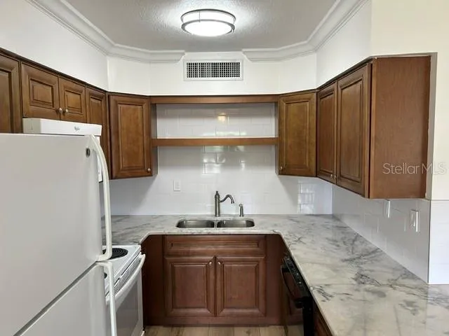 Kitchen with granite countertops, wood raised panel cabinets and a tile backspash
