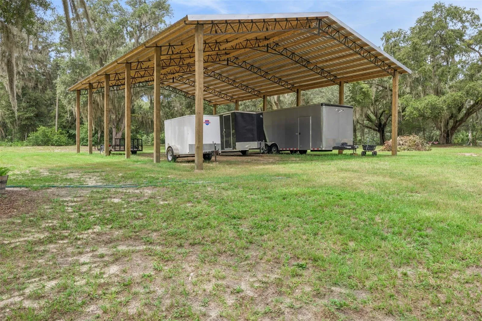 Covered pole barn provides protected storage for equipment, vehicles, boats, or RVs.