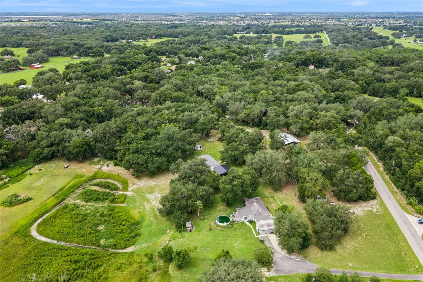 Stunning aerial view revealing the full scope of this remarkable property and its lush, oak-canopied setting.