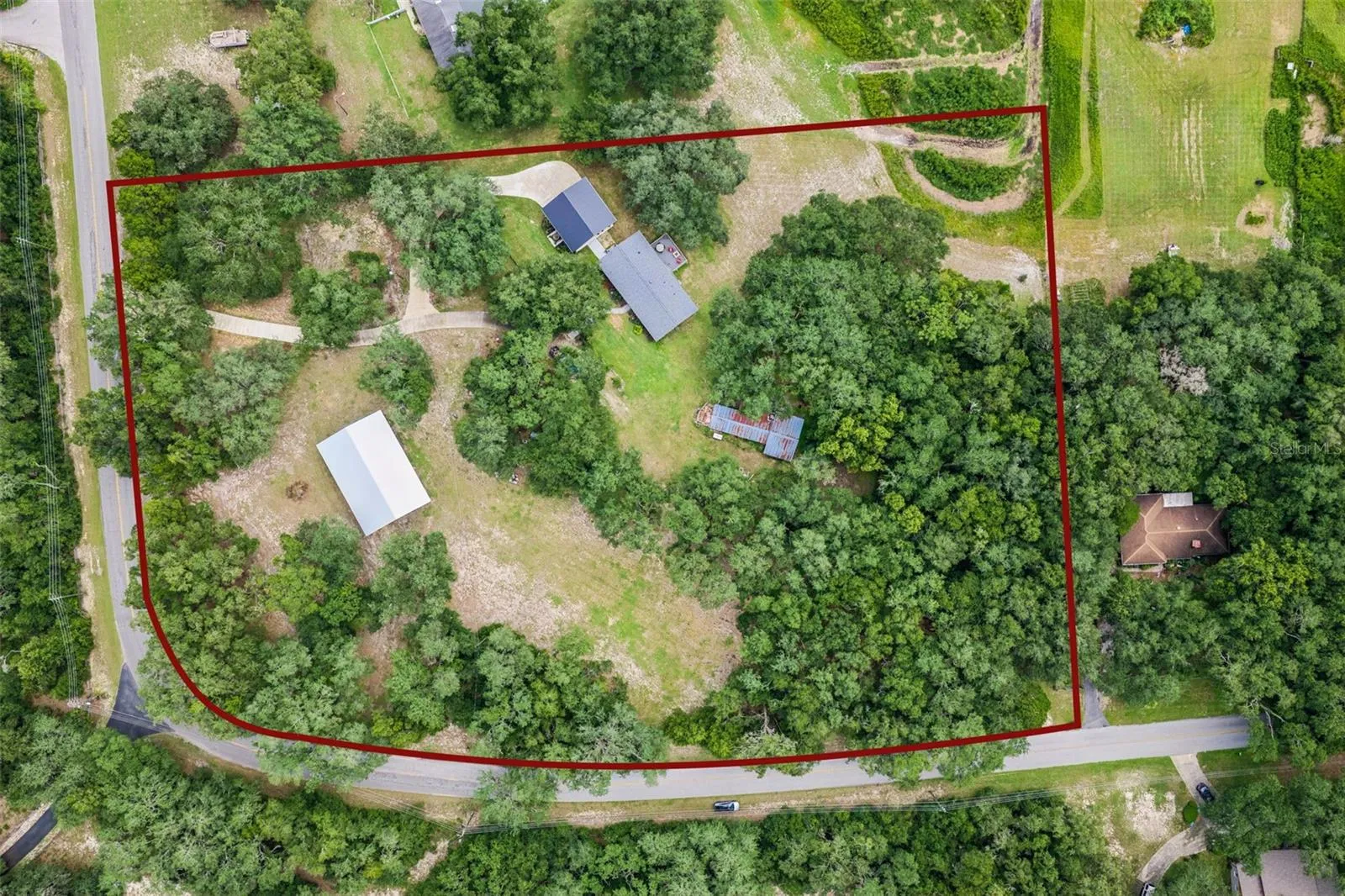Bird's-eye view showcasing the home's prime position surrounded by mature oaks and open green space.