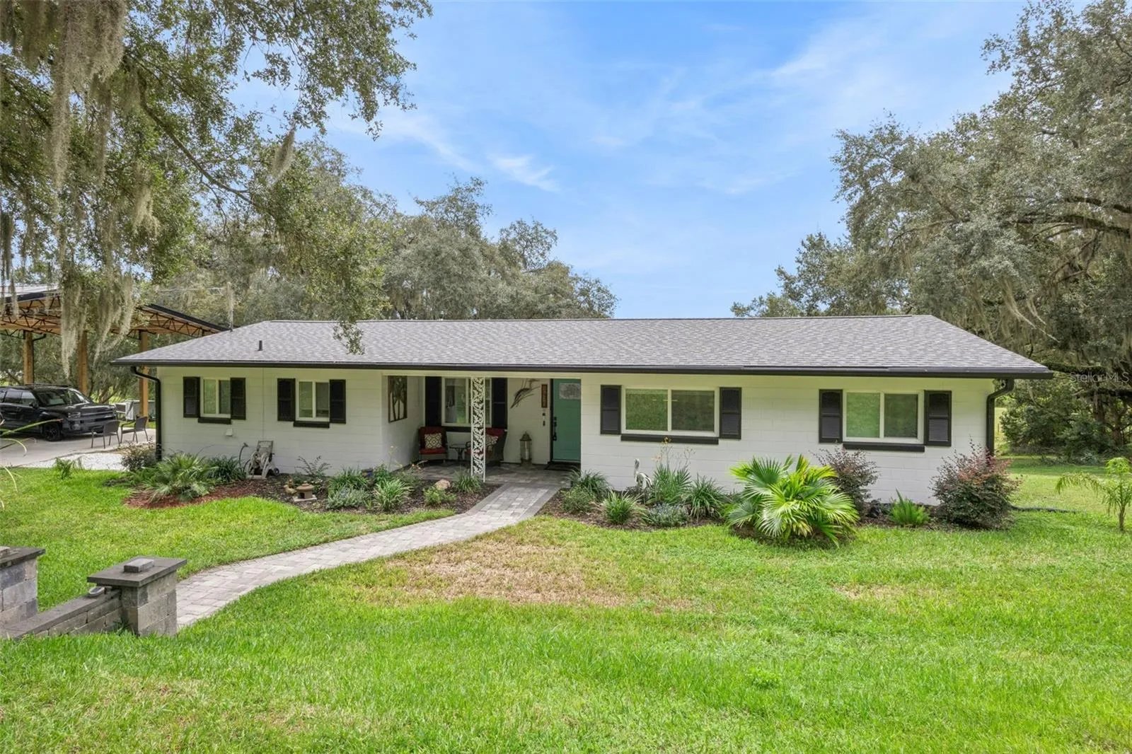 Welcome to 1476 Spring Lake Rd: a beautifully updated home with custom paver walkway, professional landscaping, and an inviting covered front entry in sought-after Fruitland Park, FL.