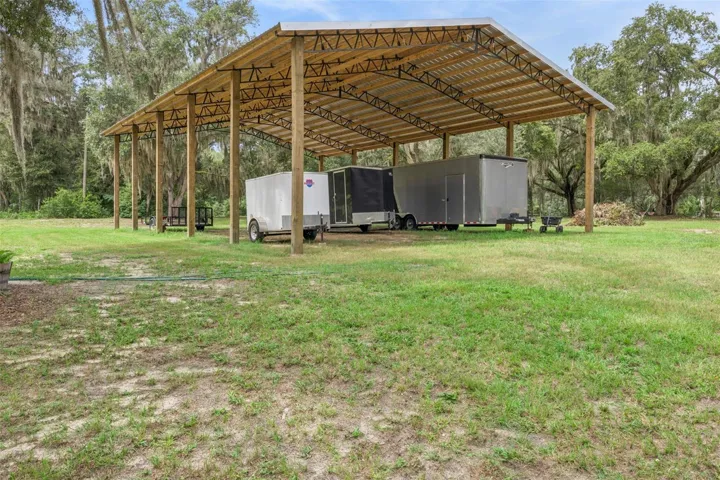 Covered pole barn provides protected storage for equipment, vehicles, boats, or RVs.
