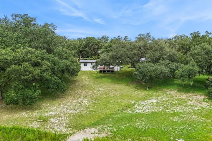 Aerial shot showcasing the property layout, outbuildings, and the incredible natural landscape.