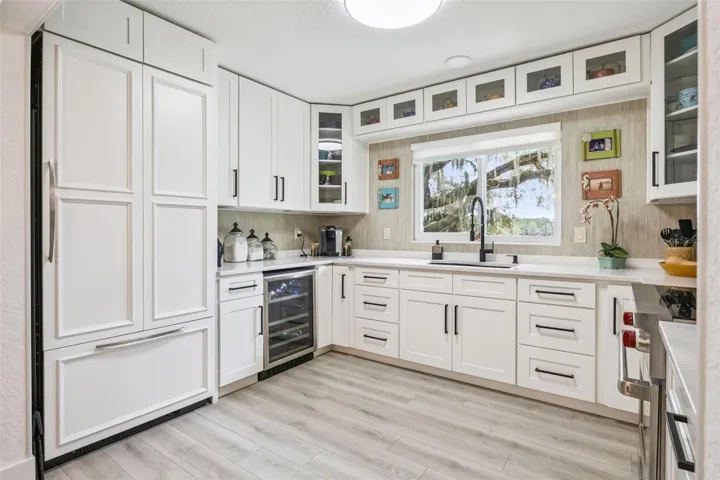 Thoughtfully appointed kitchen with a built-in wine cooler, panel-ready refrigerator, and generous counter space for meal prep and gathering.
