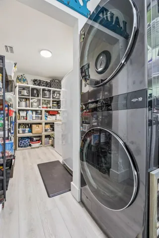 Convenient laundry area with a modern stacked LG washer and dryer, plus a generous walk-in pantry with smart storage solutions.