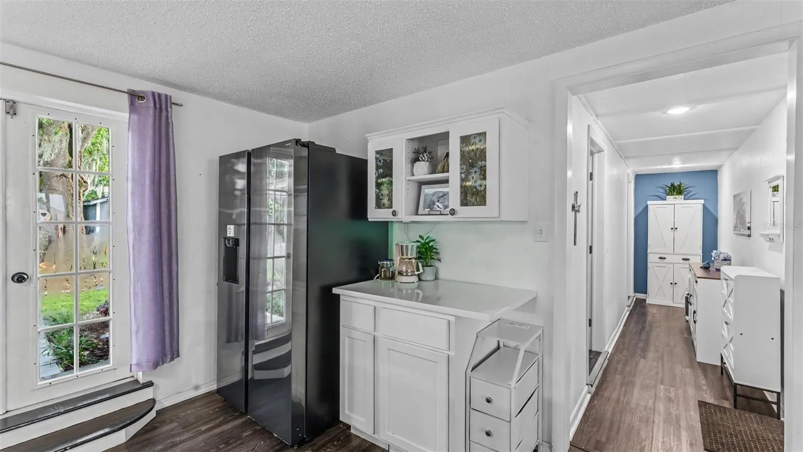 Kitchen area with french doors to the left to back yard and laundry and 2nd bathroom down hallway