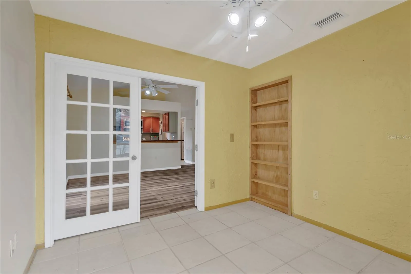 Study or office with ceiling fan and built-in bookcase.