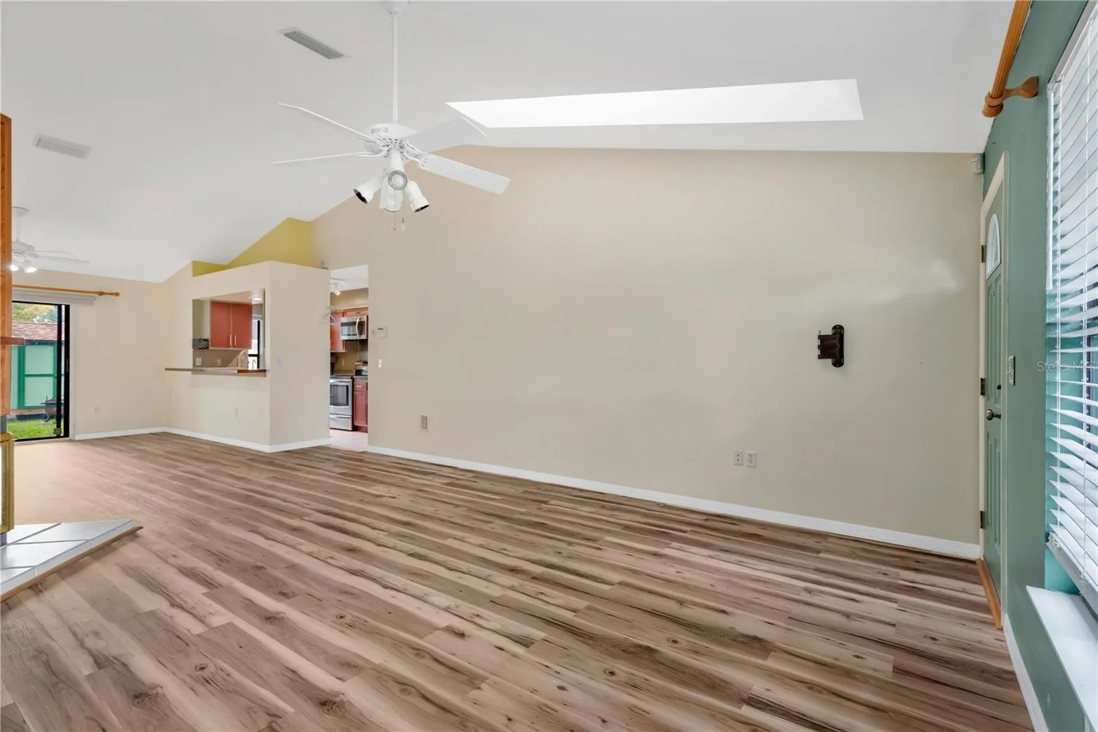 Living Room with skylights, ceiling fan and lofted ceilings.