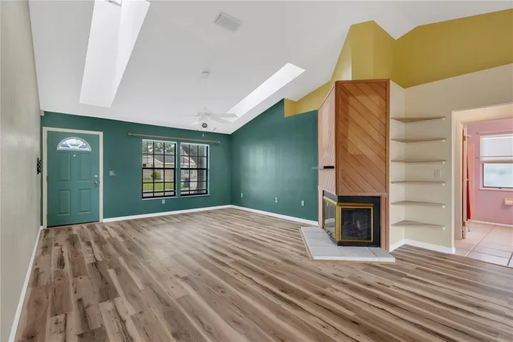 Living Room with wood burning fireplace and built in corner shelves.
