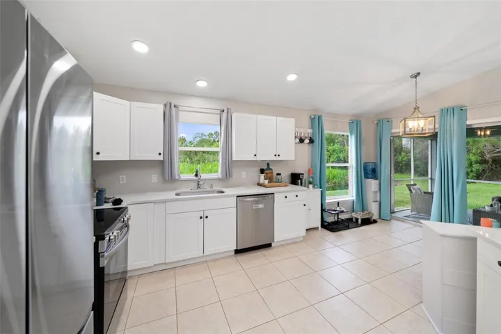 Kitchen opens to screened patio with pond/nature view