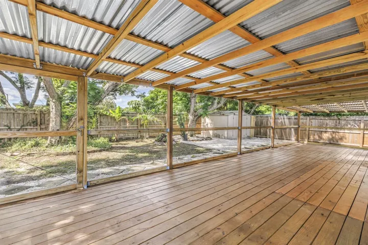 Large covered screened patio overlooks the fully fenced backyard