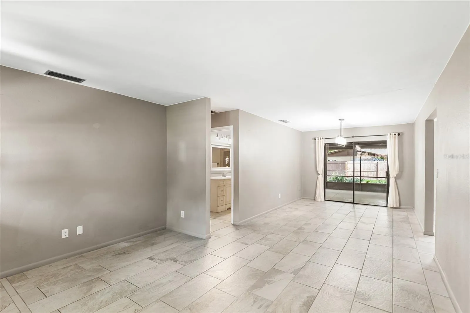 Living Room and Dining Room. Sliders lead to covered &amp; screened in room