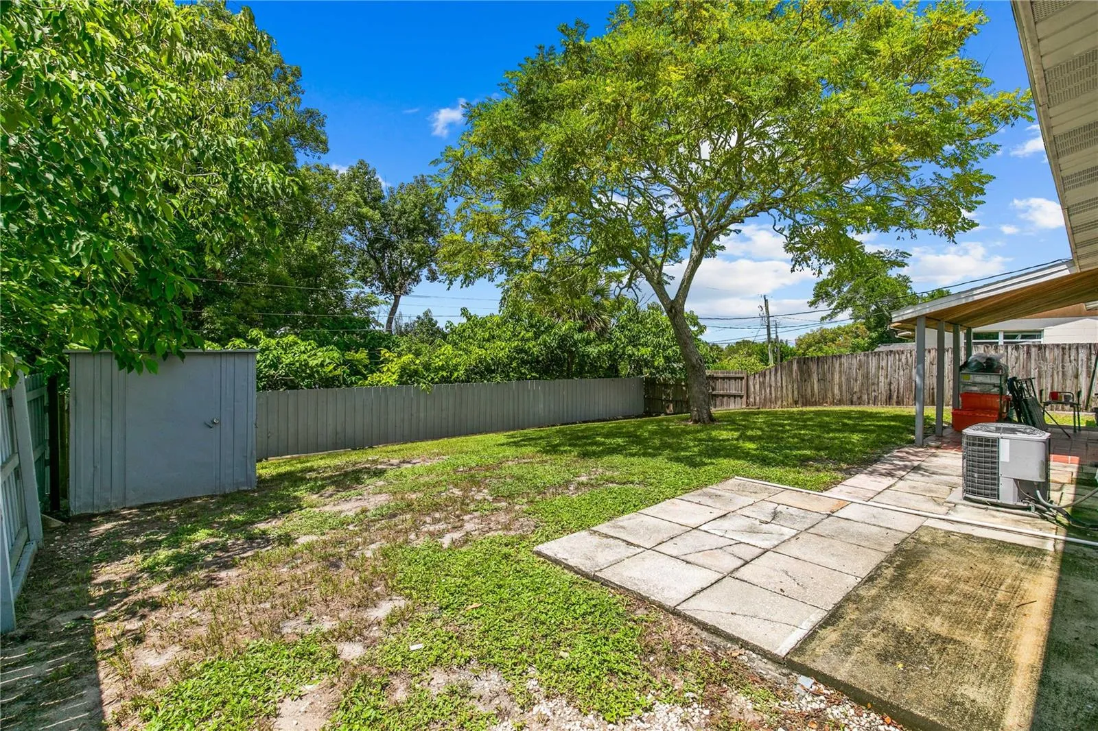 Fenced Backyard Overlooking Shed and Mature Trees