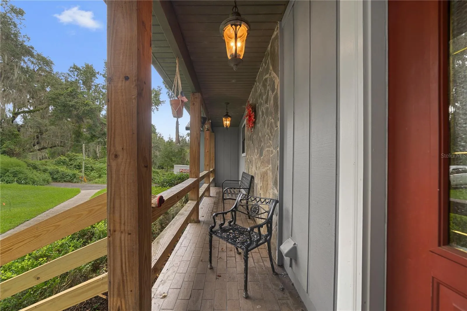 Covered front porch with seating overlooking the property.