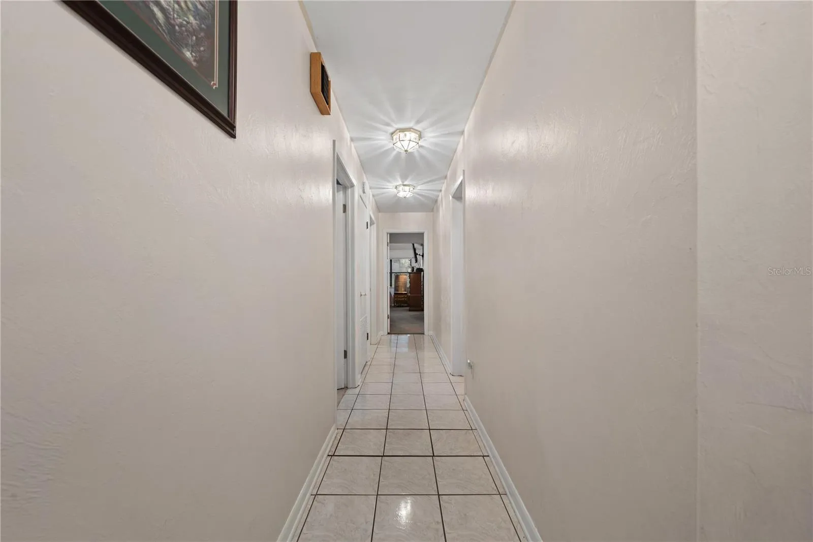 Hallway with two bedrooms to the left, the primary bedroom straight ahead, and Bathroom 2 also located on the left.