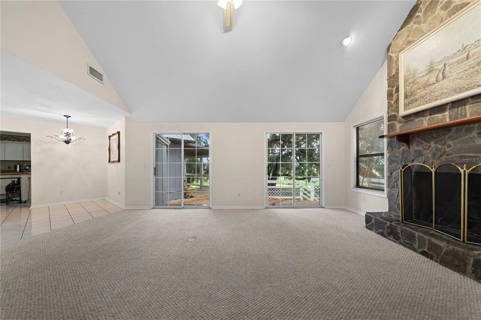 Living room featuring a fireplace and two sliding glass doors leading to the back patio.
