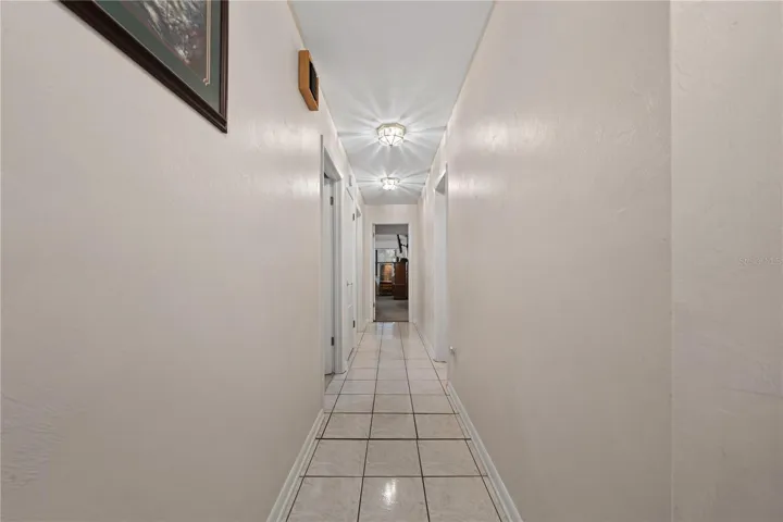 Hallway with two bedrooms to the left, the primary bedroom straight ahead, and Bathroom 2 also located on the left.