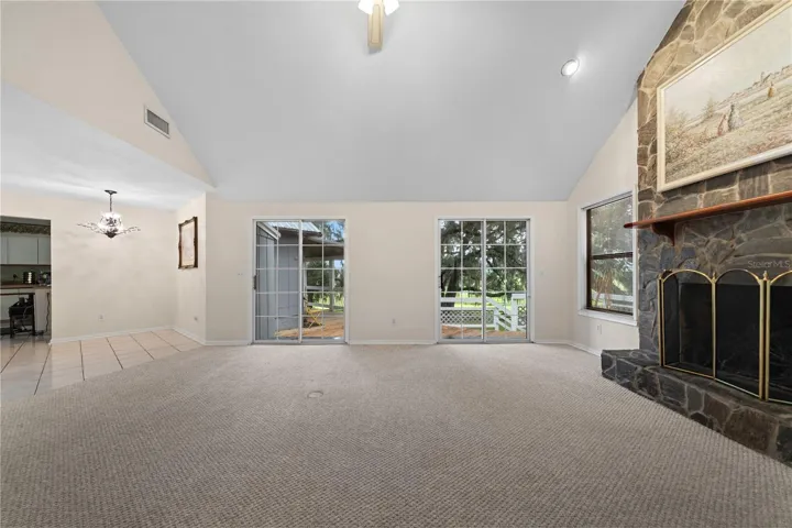 Living room featuring a fireplace and two sliding glass doors leading to the back patio.