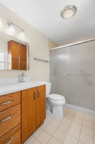 Updated bathroom with floor to ceiling tile shower, counter height vaniety