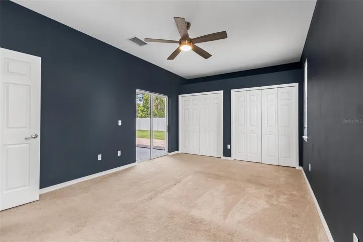 Primary bedroom dual closets and sliding glass doors to lanai.