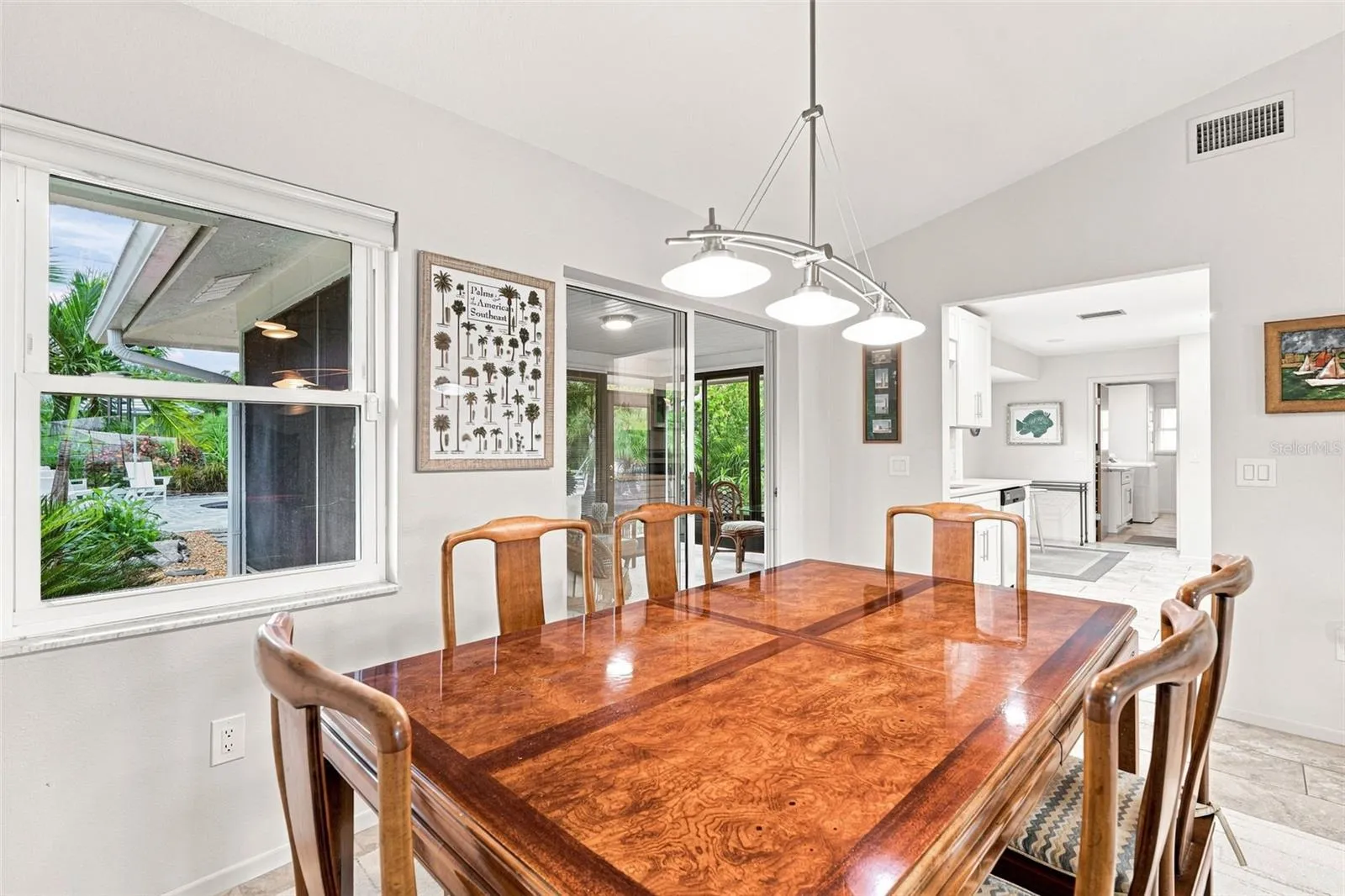 Dining Room With Sliders to Sunroom Overlooks Pool