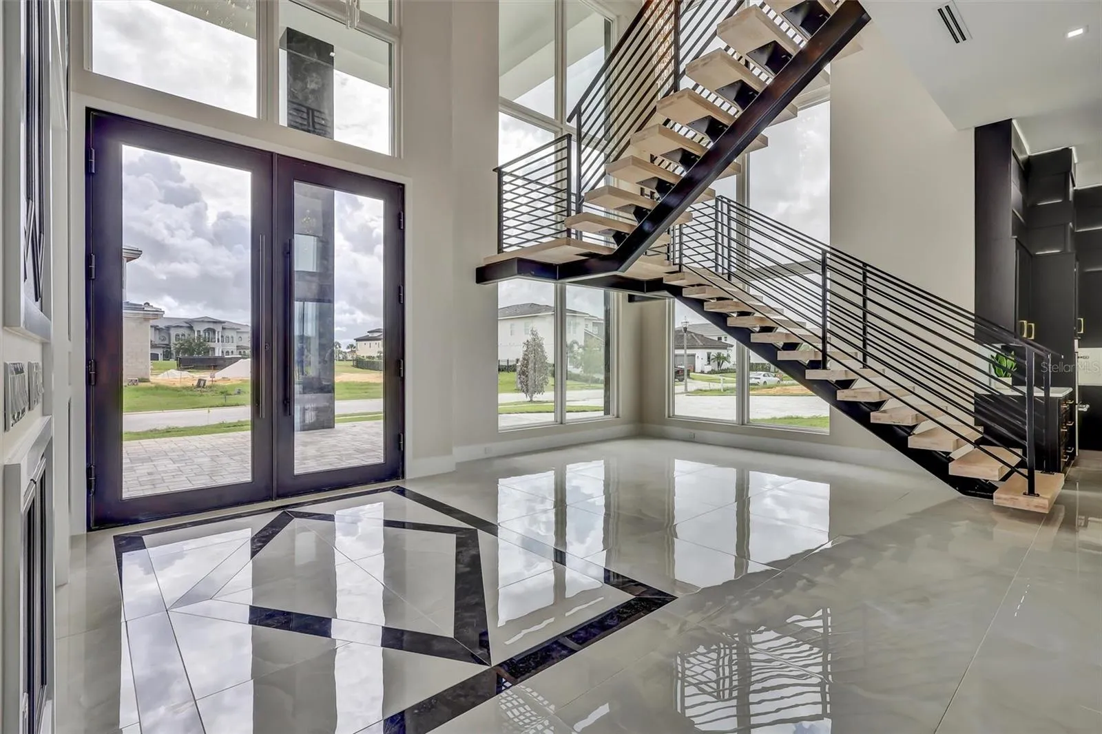 Impressive foyer with soaring glass and architectural floating staircase