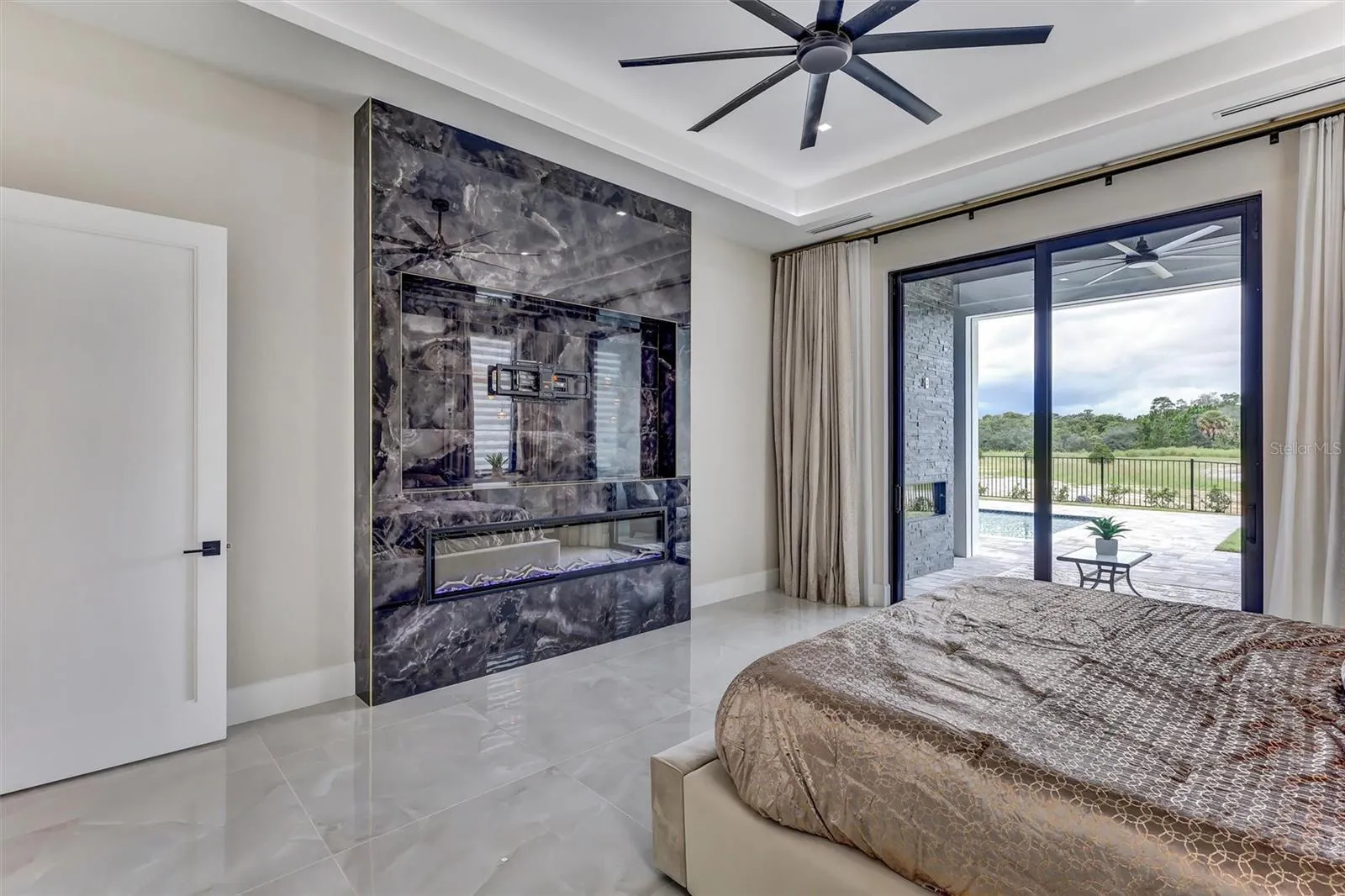 Spacious primary suite with custom feature Fireplace wall and direct outdoor access