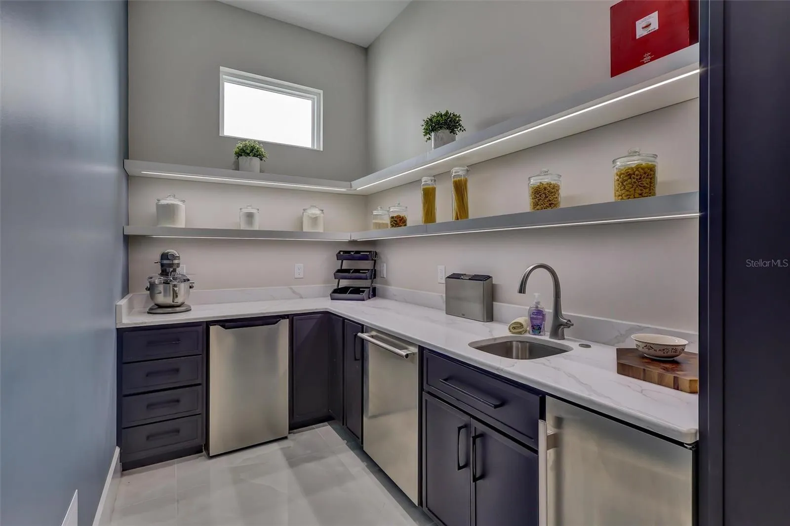 Scullery/Bulter's Pantry for prep and service space with cabinetry, sink and storage