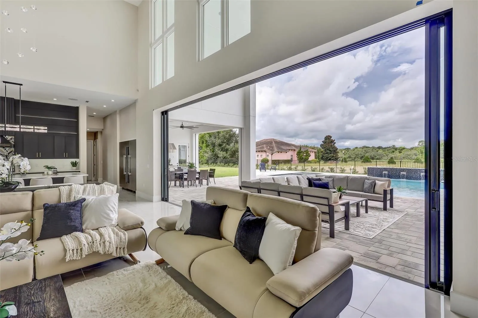 A remarkable 24-foot wall of pocketing glass doors opens completely to the covered lanai