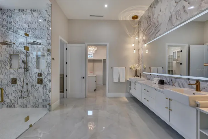 Spa-inspired primary bath with dual vanities and dramatic wet room