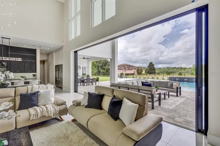 A remarkable 24-foot wall of pocketing glass doors opens completely to the covered lanai