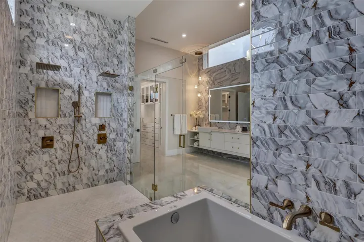 Luxurious soaking tub incorporated within the expansive primary wet room with accompanying built in seat