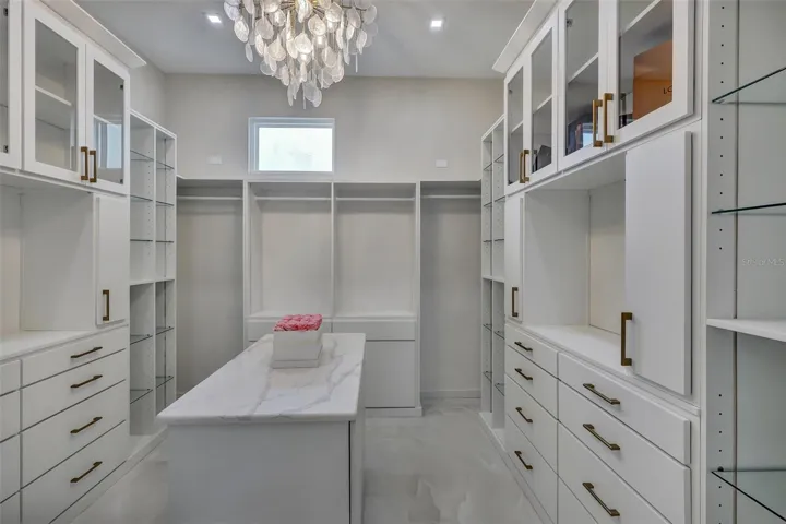 Custom primary dressing room with extensive built-in cabinetry and center island