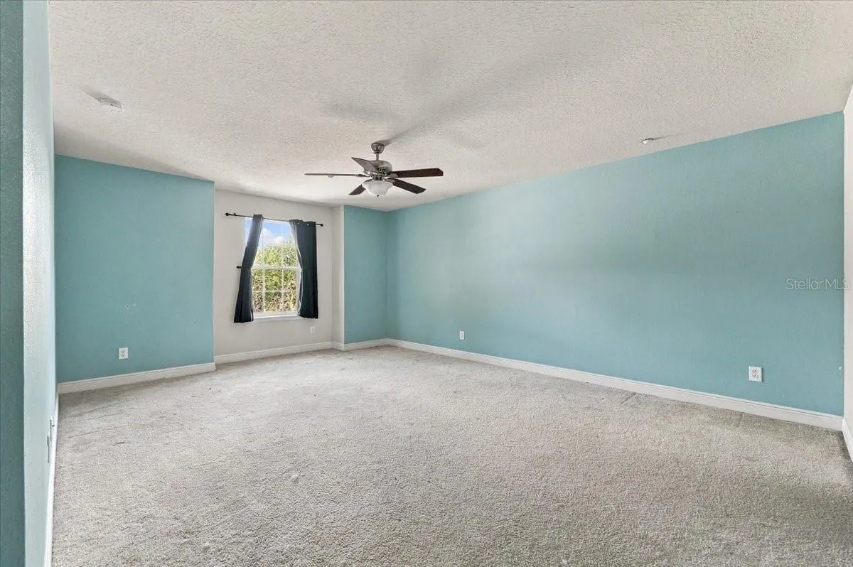 Generously sized primary suite with plush carpet