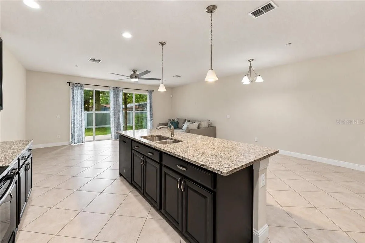 Kitchen island with pendant lighting flows seamlessly into the dining and living space