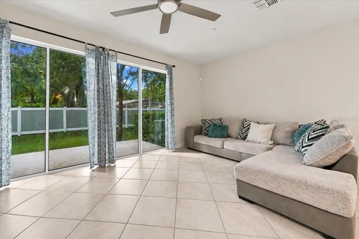 Spacious living room with sliding glass doors opening to the backyard