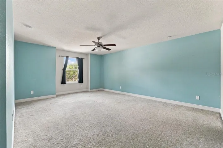 Generously sized primary suite with plush carpet