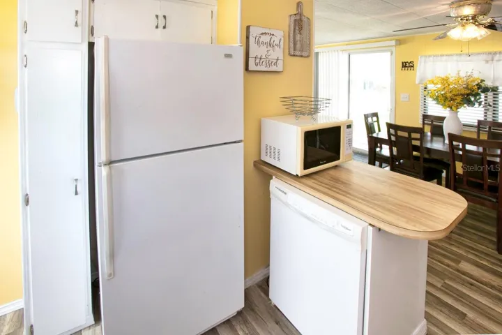 Dishwasher and microwave on top of island. Refrigerator
