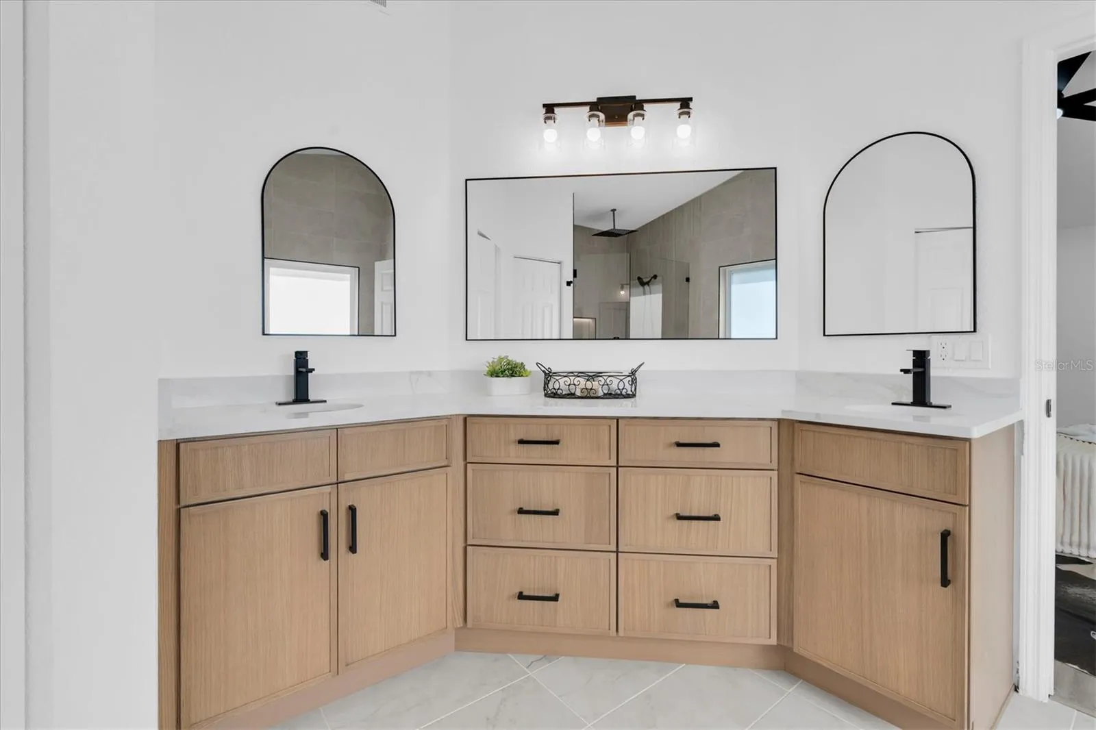 Dual vanities, private water closet and generous storage complete the redesigned primary bath.