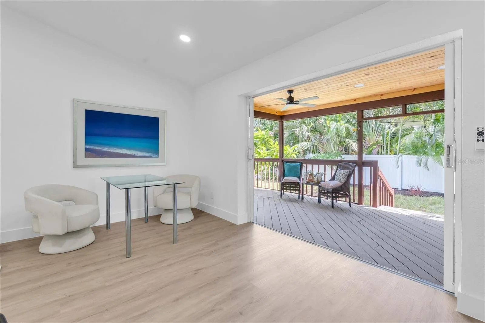Four sets of sliding glass doors connect the home to the tropical backyard and covered lanai.